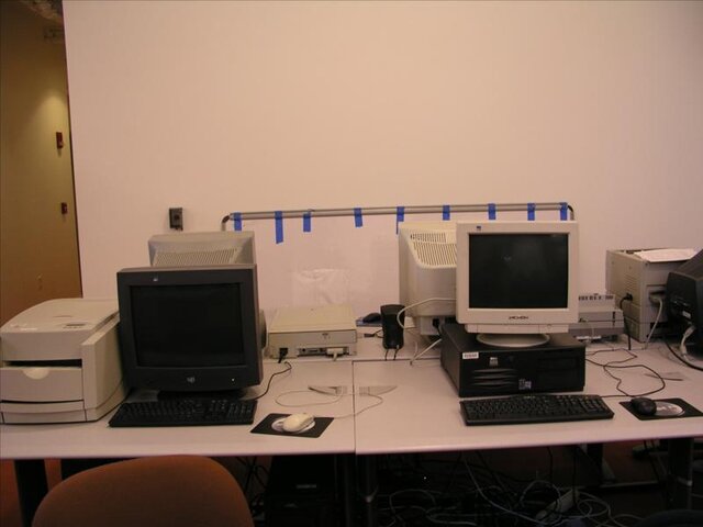 A desk with three similar computer monitors.