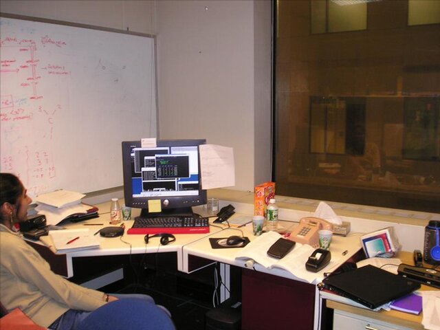 An office desk with a corded telephone sitting directly on it.